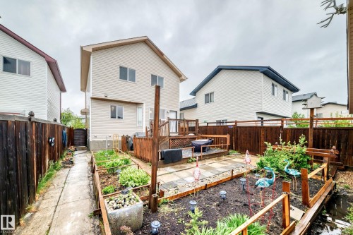 Expansive backyard featuring a multi-level wood deck, paver patio, established garden beds, and full perimeter wood fencing - 8 Campbell Court, Leduc, AB 