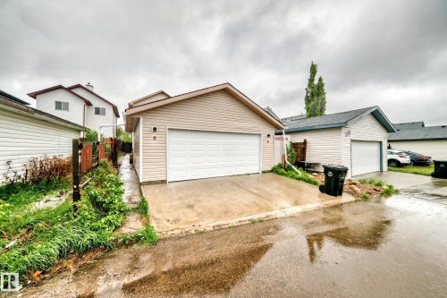 Single-car garage with a white overhead door and concrete driveway - 8 Campbell Court, Leduc, AB 