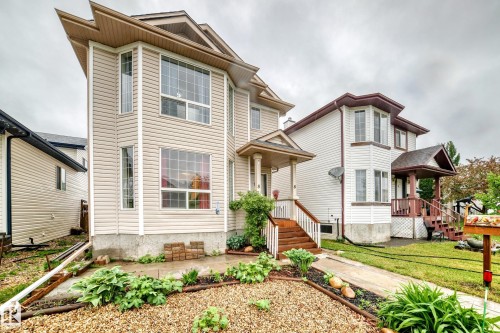 Light-toned siding exterior featuring multiple bay windows - 8 Campbell Court, Leduc, AB 