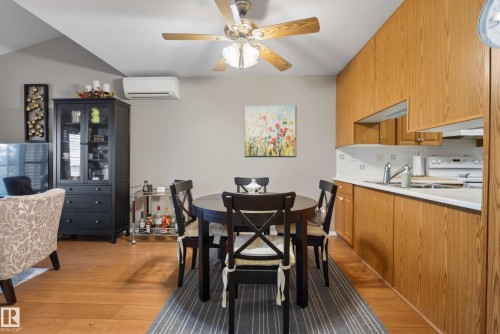Open-concept living area with wood-finish flooring, a vaulted ceiling, and a ceiling fan - 413 8912 156 Street Nw, Edmonton, AB 