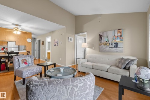 Open-concept living space featuring wood-finish flooring, recessed lighting, and a vaulted ceiling - 413 8912 156 Street Nw, Edmonton, AB 