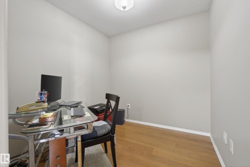 Neutral-toned walls complement wood-finish flooring and white baseboards - 413 8912 156 Street Nw, Edmonton, AB 
