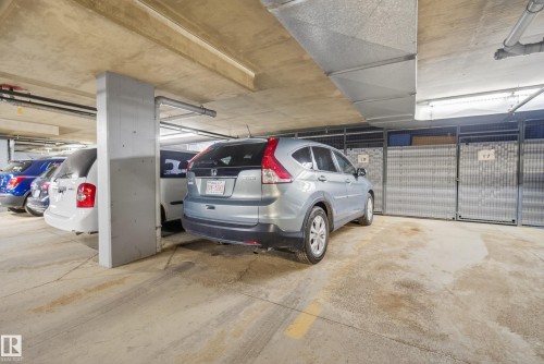Underground parking garage featuring concrete flooring, concrete ceiling, and exposed utility conduits - 413 8912 156 Street Nw, Edmonton, AB 