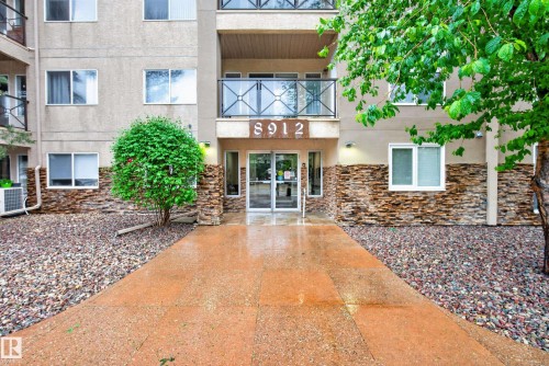 Building exterior with stone veneer accents and a prominent central entry - 413 8912 156 Street Nw, Edmonton, AB 