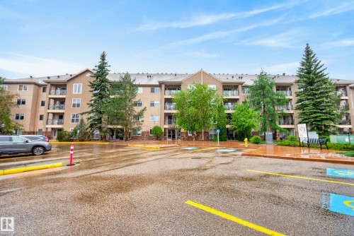 Multi-story residential building featuring a neutral-toned facade with stone accents and multiple private balconies - 413 8912 156 Street Nw, Edmonton, AB 
