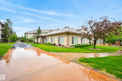 Stucco exterior with multiple windows, featuring a sloped roof and an integrated downspout system - 413 8912 156 Street Nw, Edmonton, AB 