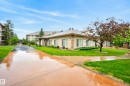 Stucco exterior with multiple windows, featuring a sloped roof and an integrated downspout system - 413 8912 156 Street Nw, Edmonton, AB 