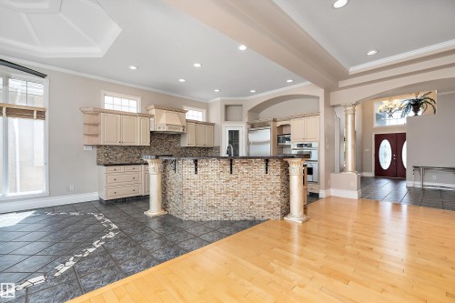 Gourmet kitchen featuring a mosaic-tiled island with decorative columns, light-toned cabinetry, and integrated appliances - 16103 89 Street, Edmonton, AB - Indoor Photo Showing Kitchen With Upgraded Kitchen