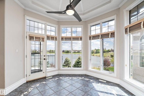 Sun-filled bay window area featuring a coffered ceiling, a contemporary ceiling fan, and large windows with lake scenery - 16103 89 Street, Edmonton, AB - Indoor Photo Showing Other Room