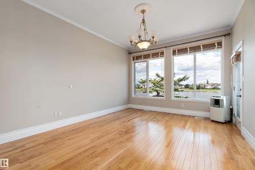 Open-concept room featuring light wood flooring, neutral wall paint, and white crown molding - 16103 89 Street, Edmonton, AB - Indoor Photo Showing Other Room