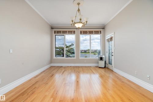 Hardwood flooring complemented by tall baseboards and crown molding - 16103 89 Street, Edmonton, AB - Indoor Photo Showing Other Room