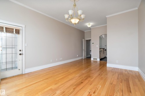 Expansive room featuring light wood-finish flooring, crisp white baseboards, and crown molding - 16103 89 Street, Edmonton, AB - Indoor Photo Showing Other Room