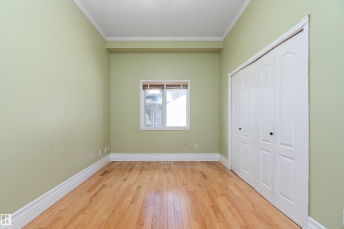 Room featuring wood-finish flooring, a window with natural light, and a bi-fold closet - 16103 89 Street, Edmonton, AB - Indoor Photo Showing Other Room