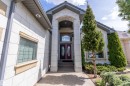 Stately home exterior featuring a prominent arched entryway with fluted columns, double red entry doors with oval glass inserts, and a transom window above - 16103 89 Street, Edmonton, AB  - Outdoor 