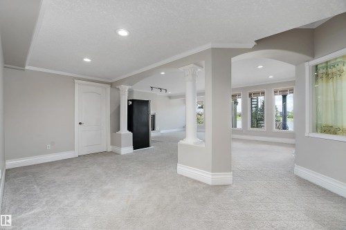 Spacious interior featuring light gray walls, patterned carpeting, and white trim - 16103 89 Street, Edmonton, AB - Indoor Photo Showing Other Room