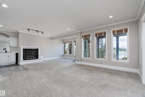 Spacious living area featuring a built-in fireplace, recessed lighting, and expansive windows - 16103 89 Street, Edmonton, AB - Indoor Photo Showing Other Room With Fireplace