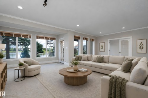 Expansive living area featuring a wall of windows, recessed lighting, crown molding, and a light-colored carpeted floor - 16103 89 Street, Edmonton, AB - Indoor Photo Showing Living Room