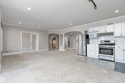 Open-concept living area featuring light-toned carpet and recessed lighting - 16103 89 Street, Edmonton, AB - Indoor Photo Showing Kitchen