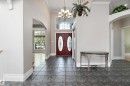 Grand entryway featuring rich red double doors with oval glass inserts, and a transom window above - 16103 89 Street, Edmonton, AB  - Indoor Photo Showing Other Room 
