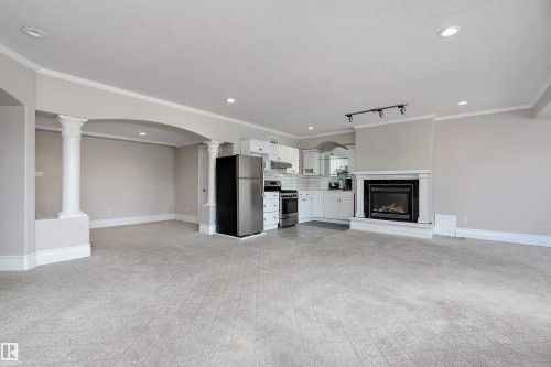 Open-concept space featuring a built-in fireplace with a white mantel, recessed lighting, and crown molding - 16103 89 Street, Edmonton, AB - Indoor With Fireplace
