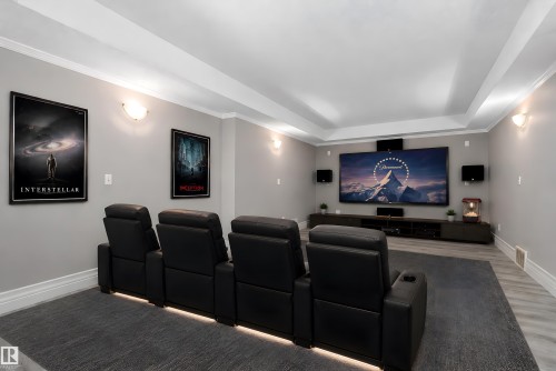 Home theater featuring a large projection screen, dedicated sound system, and tray ceiling - 16103 89 Street, Edmonton, AB - Indoor Photo Showing Other Room