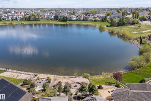 Private backyard featuring a fire pit area, mature landscaping, and direct access to the waterfront - 16103 89 Street, Edmonton, AB - Outdoor With Body Of Water With View