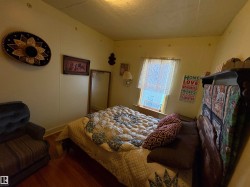 Room featuring wood-finish flooring, a single window, and light-toned walls. - 