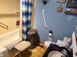 Bathroom featuring a full tub with shower, blue wall paint, a vanity with an integrated sink. - 