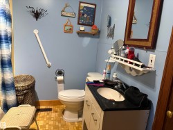 Bathroom featuring a single vanity with a black countertop, toilet. - 