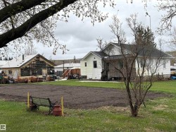 Expansive yard featuring a large tilled garden area. - 