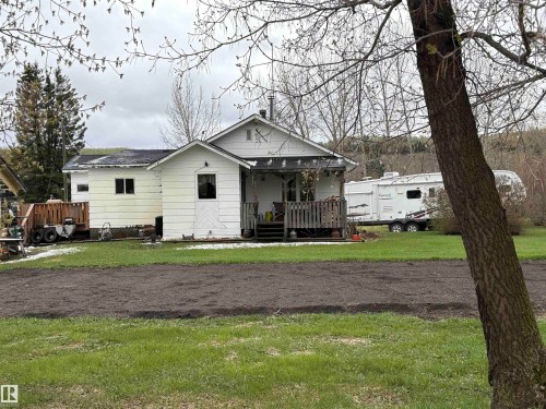 White-sided residence featuring a covered porch with dark wood railing. - 125 56524 Rng Rd 52A, Lindbergh, AB 