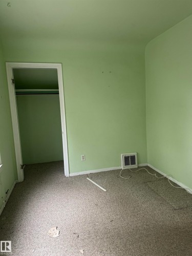 Room featuring light green painted walls and grey carpet flooring - 9740 87 Avenue, Edmonton, AB 