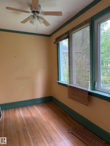 Den with wood-finish flooring. - 9740 87 Avenue, Edmonton, AB 