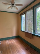 Den with wood-finish flooring. - 