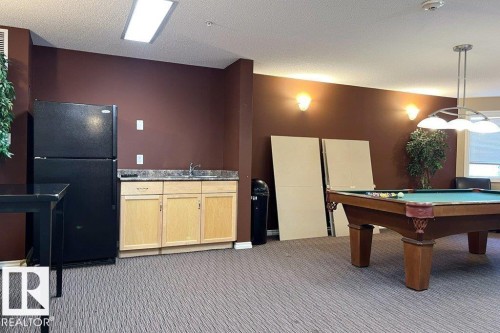 Game room with a textured ceiling and pool table - 303 5951 165 Avenue, Edmonton, AB 