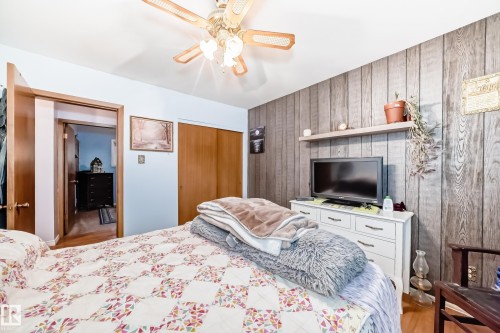 Room featuring light blue walls and a wood-panel accent wall - 8006 159 Street, Edmonton, AB 