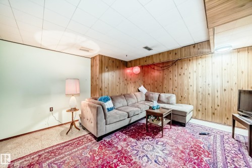 Recreation room featuring wood paneling, a drop ceiling, and light-colored walls - 8006 159 Street, Edmonton, AB 