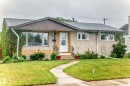 Front exterior showcasing a composite shingle roof, stucco and brick facade, white framed windows, and a curved concrete walkway - 8006 159 Street, Edmonton, AB 