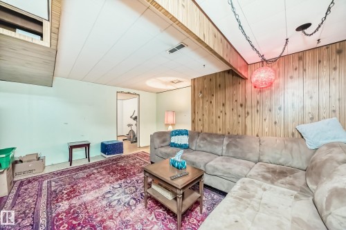 Recessed ceiling paneling and wood-paneled walls define this versatile interior space - 8006 159 Street, Edmonton, AB 