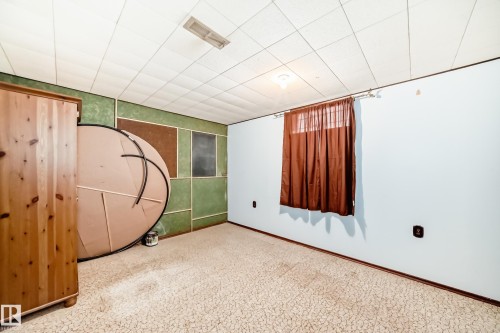 Room featuring light-toned patterned carpet and a drop ceiling with recessed lighting - 8006 159 Street, Edmonton, AB 