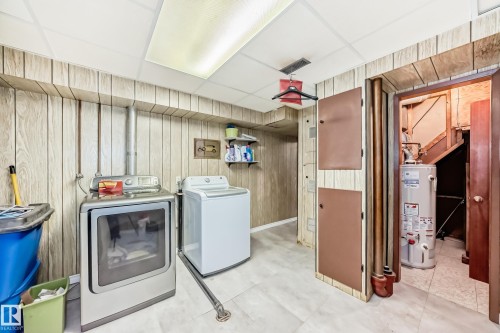 Utility area featuring wood-finish wall paneling, a drop ceiling with integrated lighting, and light-toned flooring - 8006 159 Street, Edmonton, AB 
