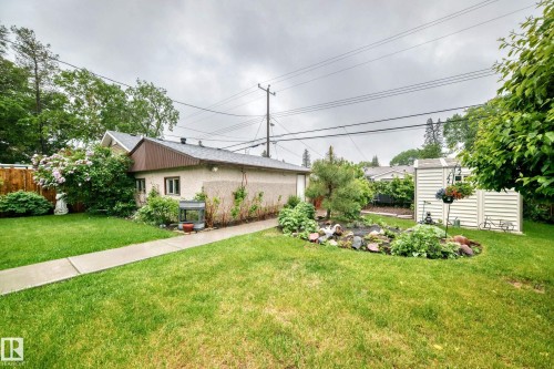 Expansive green lawn with a concrete pathway leading to a stucco-exterior structure - 8006 159 Street, Edmonton, AB 
