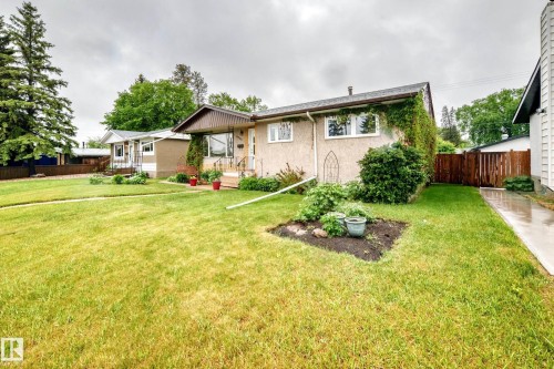 Front exterior featuring a covered entry porch, stucco siding, and multiple windows - 8006 159 Street, Edmonton, AB 
