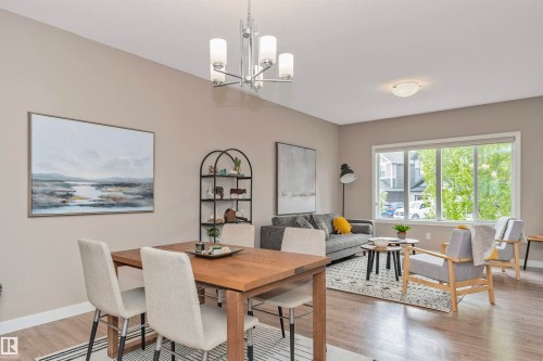 Open-concept living and dining area featuring wood-finish flooring and neutral wall tones - 22124 85 Avenue, Edmonton, AB - Indoor