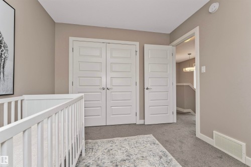 Neutral-toned wall paint with white trim, contemporary five-panel interior doors, plush gray carpeting, and a white ceiling-mounted smoke detector - 22124 85 Avenue, Edmonton, AB - Indoor Photo Showing Other Room