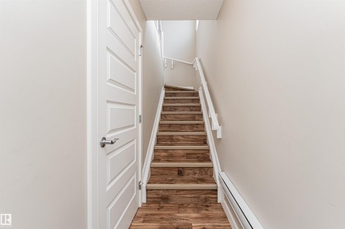 Staircase featuring wood-finish treads and risers, white painted handrails, and neutral wall tones - 22124 85 Avenue, Edmonton, AB - Indoor Photo Showing Other Room