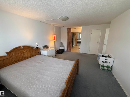 Carpeted room featuring a ceiling-mounted light fixture and white walls - 225 4404 122 Street, Edmonton, AB 