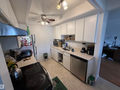 Compact kitchen featuring white cabinetry, light-colored countertops, and tile flooring - 225 4404 122 Street, Edmonton, AB 