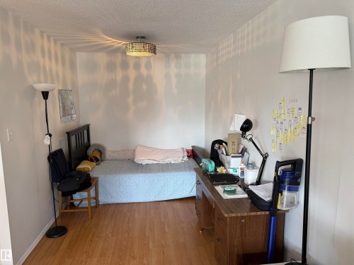 Room featuring light wood-finish flooring, white walls, and a textured ceiling - 225 4404 122 Street, Edmonton, AB 