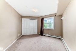 Neutral-toned room featuring a double bi-fold closet, a window with white trim, and baseboard heating - 